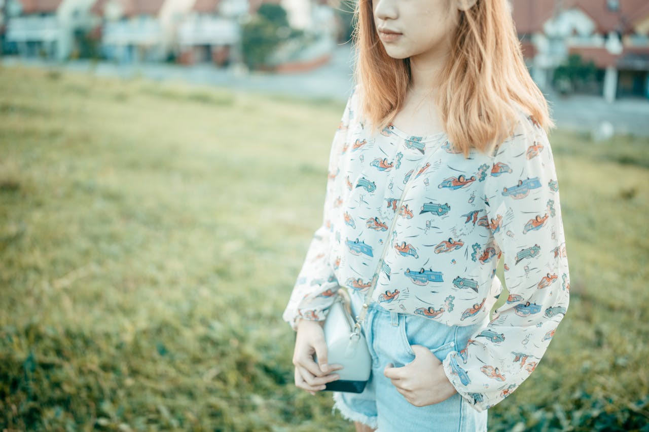 Young woman with blonde hair in a patterned blouse standing outdoors on a sunny day in Cavite City.